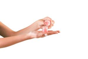 femmina mano Tenere crema bottiglia di lozione isolato. ragazza apertura vaso cosmetico prodotti su bianca sfondo foto