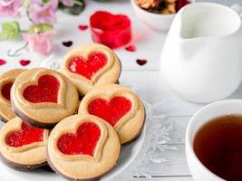 fatti in casa biscotti con un' rosso marmellata cuore San Valentino giorno tazza di tè foto