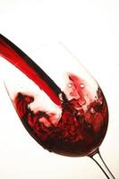 vino rosso che viene versato in un bicchiere foto