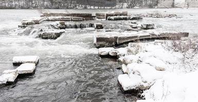 fiume con rocce neve e ghiaccio nel inverno foto