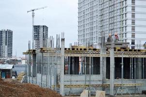 Lavorando maschio costruttori siamo Lavorando su il tetto di un' grande monolitico telaio Casa, costruzione, e nuovo edificio sotto costruzione. costruzione di il edificio nel il nuovo micro quartiere di il grande città foto