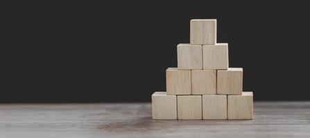 il cubo di legno si dispone a forma di piramide, concetto di business foto