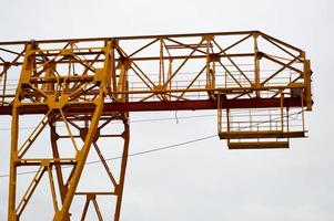 alto pesante giallo metallo ferro portante costruzione stazionario industriale potente cavalletto gru di ponte genere su supporti per sollevamento carico su un' moderno costruzione luogo di edifici e case foto