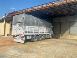 un' grande bianca potente camion con un tenda e un' trailer è parcheggiata per scaricare carico foto