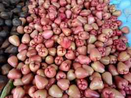 mazzo di dolce rosso acqua guaiava frutta parecchi frutta posto su di legno tavolo su naturale sfondo per vendita nel frutta negozio foto