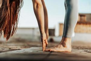 donna fare yoga all'aperto su un' tetto terrazza foto