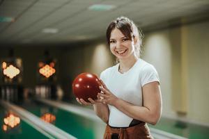 giovane donna avendo divertimento nel un' bowling vicolo foto