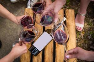 persone tintinnante bicchieri con vino su il estate terrazza di bar o ristorante foto