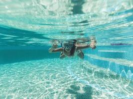 bambino ragazza nuotare subacqueo nel piscina foto