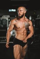 fitness uomo mostrando il suo muscoli a il Palestra foto