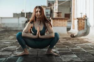 donna fare yoga all'aperto su un' tetto terrazza foto