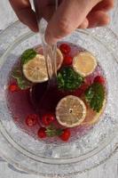 rosso salutare bevanda con agrume frutta fetta e bacche nel il bicchiere ciotola con il mestolo. foto