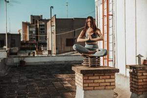 donna fare yoga all'aperto su un' tetto terrazza foto