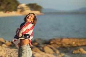 donna con noi nazionale bandiera godendo giorno su un' spiaggia foto