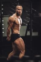 fitness uomo mostrando il suo muscoli a il Palestra foto