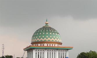 il cupola di il moschea è avvolto nel nuvoloso nuvole. semplice foto di moschea e nuvoloso. religioso foto per il design di il celebrazione di religioso attività