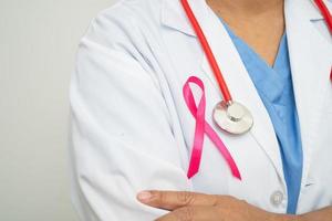 Seno cancro, asiatico medico donna con rosa nastro, simbolo di mondo Seno cancro giorno. foto