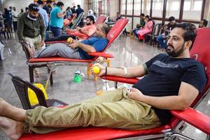 delhi, india, 19 giugno 2022 - donatore di sangue al campo di donazione di sangue tenuto al tempio di balaji, immagine per la giornata mondiale del donatore di sangue il 14 giugno di ogni anno, vivek vihar, delhi, india, campo di donazione di sangue al tempio foto