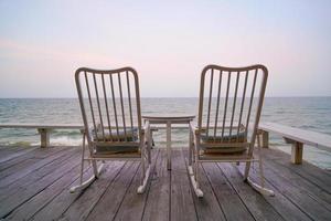 vuoto sedia su balcone con mare sfondo foto