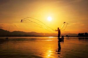gettando la rete da pesca durante il tramonto
