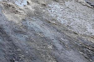 danneggiato asfalto strada con buche causato di congelamento e scongelamento cicli durante il inverno. povero strada foto