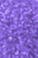 sfocato viola decorativo paillettes. sfondo Immagine con brillante bokeh luci a partire dal piccolo elementi foto