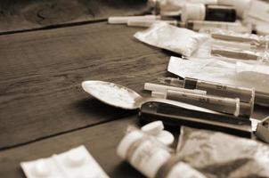 un' lotto di narcotico sostanze e dispositivi per il preparazione di farmaci menzogna su un vecchio di legno tavolo foto
