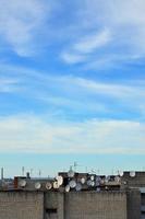 un' lotto di satellitare televisione antenne su il tetto sotto un' blu cielo foto