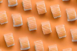 Filadelfia rotoli con salmone su arancia sfondo. minimalismo superiore Visualizza piatto posare modello con giapponese cibo foto