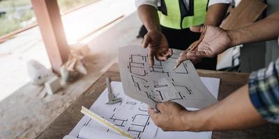 civile ingegnere squadre incontro Lavorando insieme indossare lavoratore caschi elmetto protettivo su costruzione luogo nel moderno città. caposquadra industria progetto manager ingegnere lavoro di squadra. foto