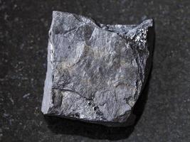 ruvido carbonioso roccia scistosa pietra su buio foto