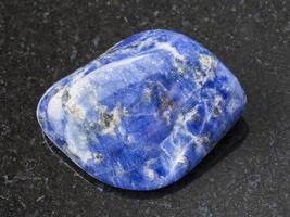 caduto sodalite pietra preziosa su buio sfondo foto