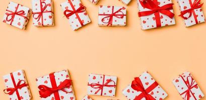 superiore Visualizza di festivo regalo scatole e rosso tessile cuori su colorato sfondo con copia spazio. st San Valentino giorno concetto foto