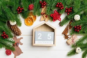 superiore Visualizza di abete albero rami su di legno sfondo. calendario decorato con festivo giocattoli. il venti quinto di dicembre. Natale tempo concetto foto