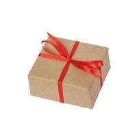 regalo scatola avvolto nel Marrone riciclato carta con rosso nastro arco superiore Visualizza isolato su bianca sfondo, ritaglio sentiero incluso foto