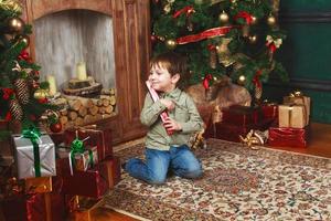 bambino ragazzo seduta sotto il Natale albero con regalo scatola foto