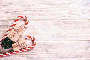 caramella canne e Natale regalo su Marrone di legno sfondo. tonica foto