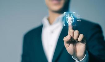 uomo d'affari lettura e biometrico autenticazione su virtuale schermo, impronta digitale scansione fornisce sicurezza accesso concetto, futuro attività commerciale sicurezza tecnologia e cibernetica. foto