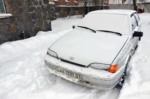Kharkov, Ucraina - gennaio 4, 2022 un' parcheggiata auto sotto un' di spessore strato di neve. conseguenze di un' forte e inaspettato nevicata nel Ucraina foto
