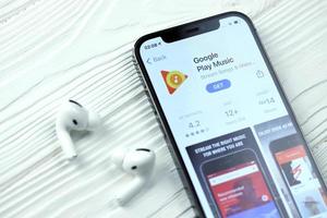 Kharkov, Ucraina - Maggio 12, 2022 Google giocare icona e applicazione a partire dal App memorizzare su i phone 12 professionista Schermo schermo con airpods professionista su bianca tavolo foto