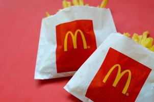 Kharkov. Ucraina - Maggio 17, 2022 McDonald's francese patatine fritte nel piccolo sacchetto di carta su luminosa rosso sfondo foto