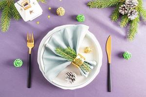 superiore Visualizza di il festivo servendo di il nuovo anni tavolo nel il classico stile. su un' buio sfondo leggero piatti, verde rami di abete rosso, lanterna. foto