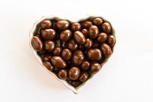 cioccolato coperto arachidi nel un' cuore sagomato ciotola foto