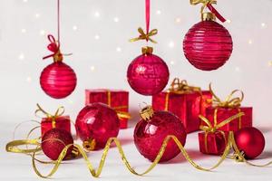 rosso Natale palle, serpentina e nuovo anni i regali su un' leggero sfondo foto