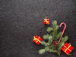 caramello canna, i regali, con Natale albero rami e Natale giocattoli su un' buio sfondo. foto