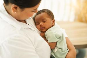 neonato bambino di un mese addormentato bene, senza preoccupazioni su il caldo La madre di il petto. giovane madre coccole adorabile infantile innocenza dopo nascita su braccia. concetto di genitorialità, maternità, foto