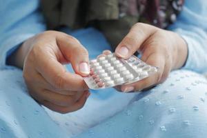 la mano delle donne che tiene le pillole anticoncezionali si chiuda foto