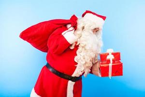 Babbo Natale con doni sulle mani su sfondo blu
