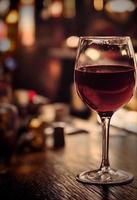 alto bicchiere di rosso vino nel un' pub foto