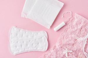sanitario pad, mestruale tazza, tampone e mutandine su un' rosa sfondo foto